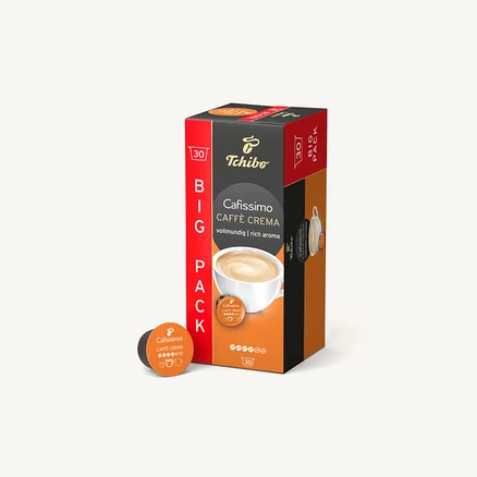 Balení kapslí Tchibo Cafissimo Caffe Crema stojí na bílém pozadí. Vedle leží jedna kapsle.