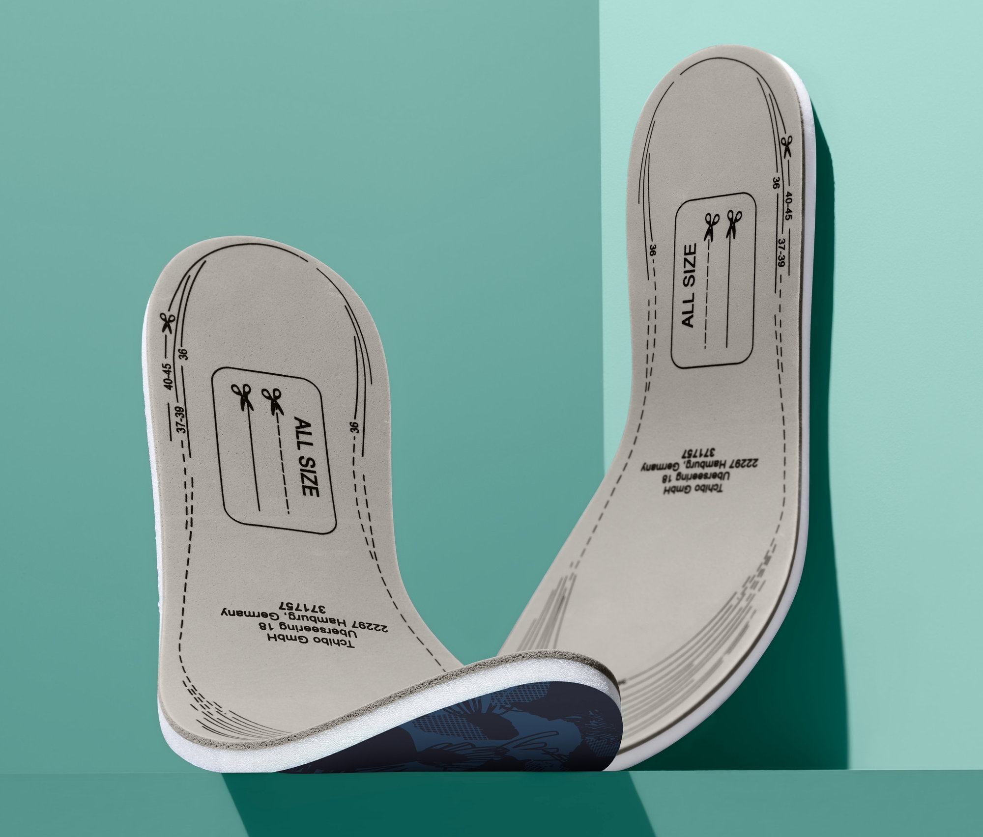 Dvě viskoelastické vložky do bot leží na sobě na zeleném pozadí.