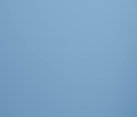 Žena pózuje v šedých pohodlných kalhotách na židli.