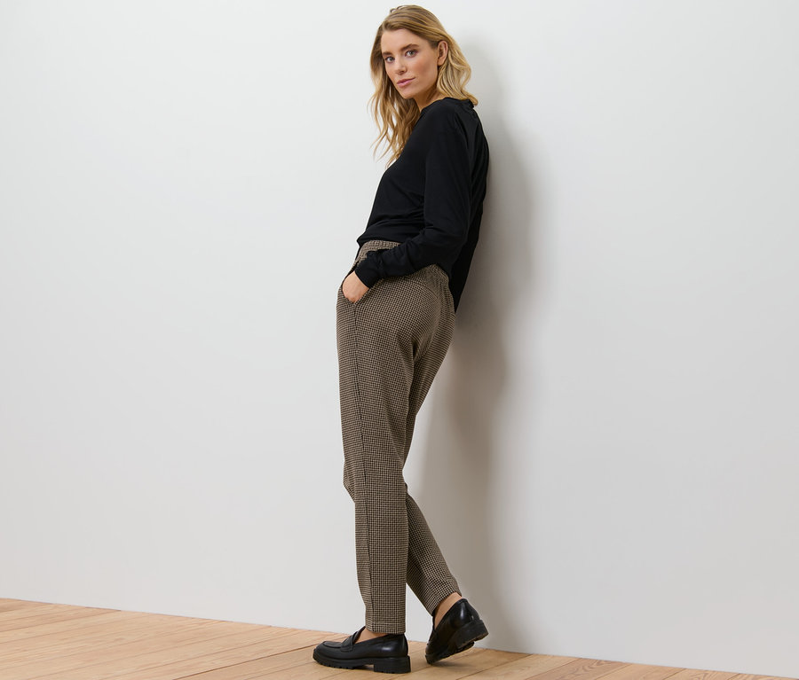 Žena pózuje v žakárových kalhotách.