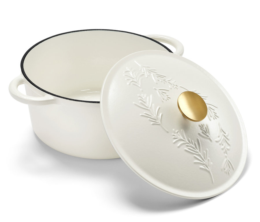 Bílý litinový hrnec s poklicí zdobenou motivem rostlin.