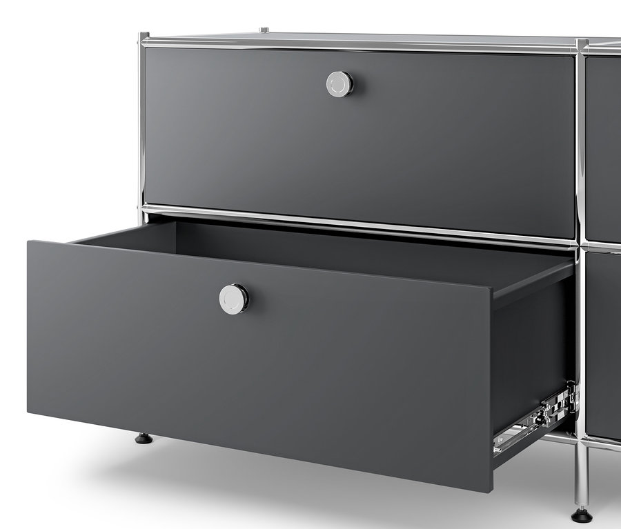 Detail šedé kovové komody »CN3« se 3 zásuvkami, přičemž jedna zásuvka je otevřená.