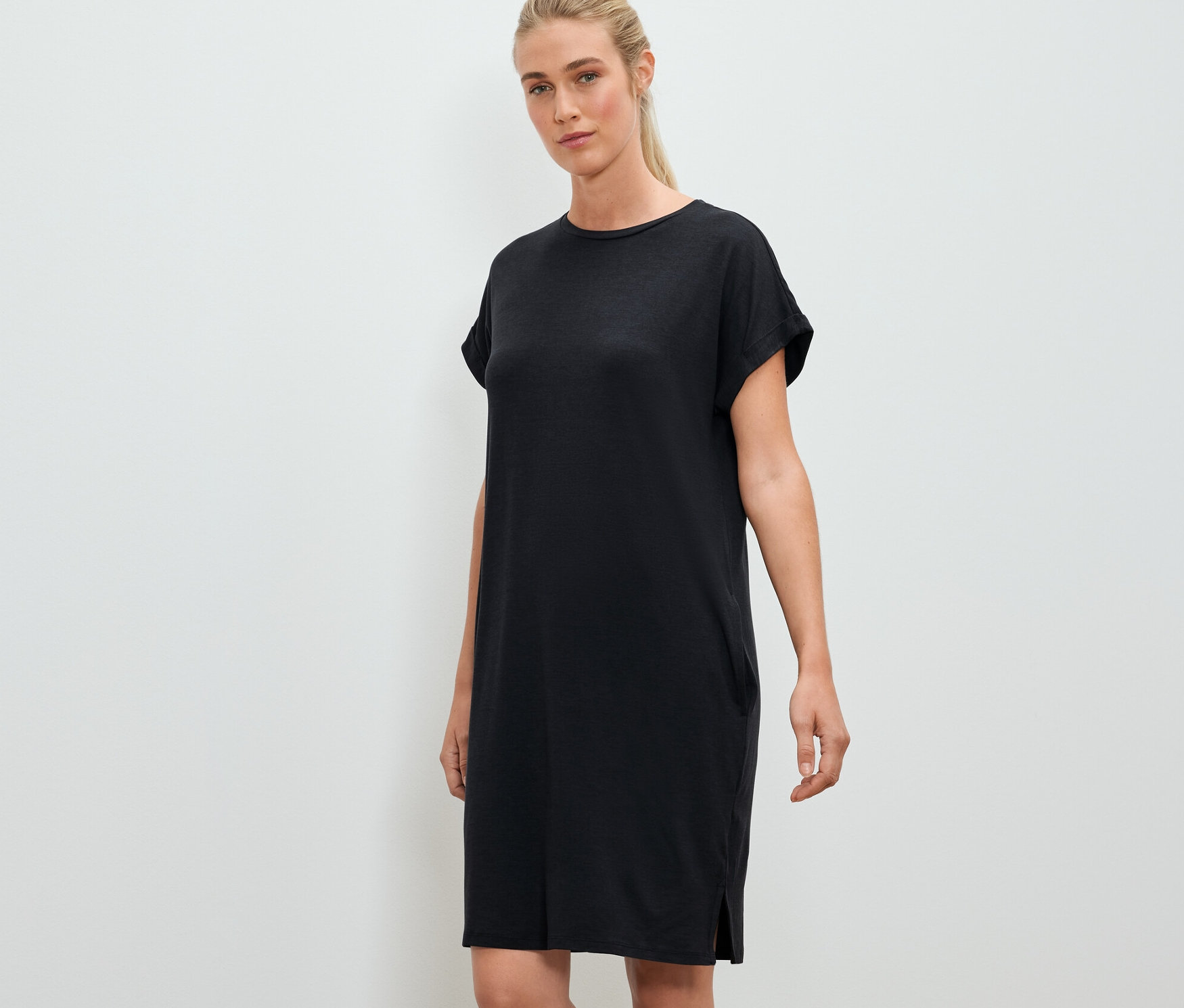 Žena pózuje na sobě černé outdoorové šaty.