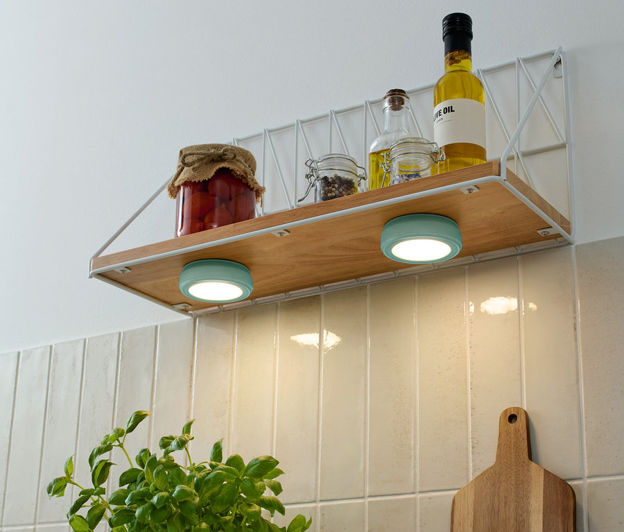 Na polici jsou sklenice s potravinami a lahve s olejem, pod nimi jsou dvě tyrkysové 2 LED-Multifunktionsleuchten.