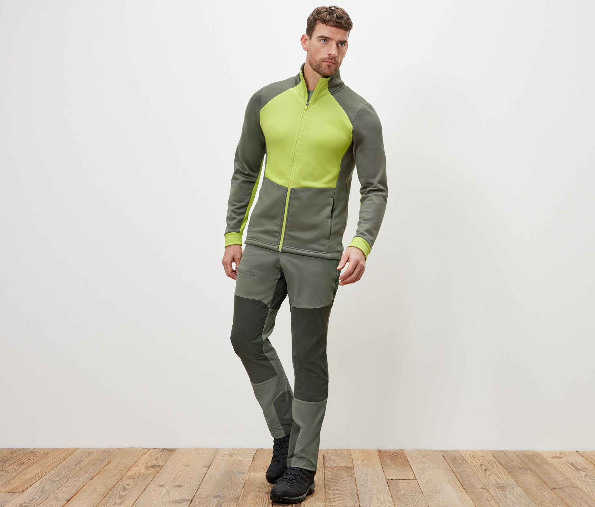 Muž pózuje v termobundě a kalhotách.