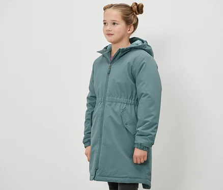 Dívka stojí bokem a má na sobě zelenou termo parku Kinder-Thermoparka.