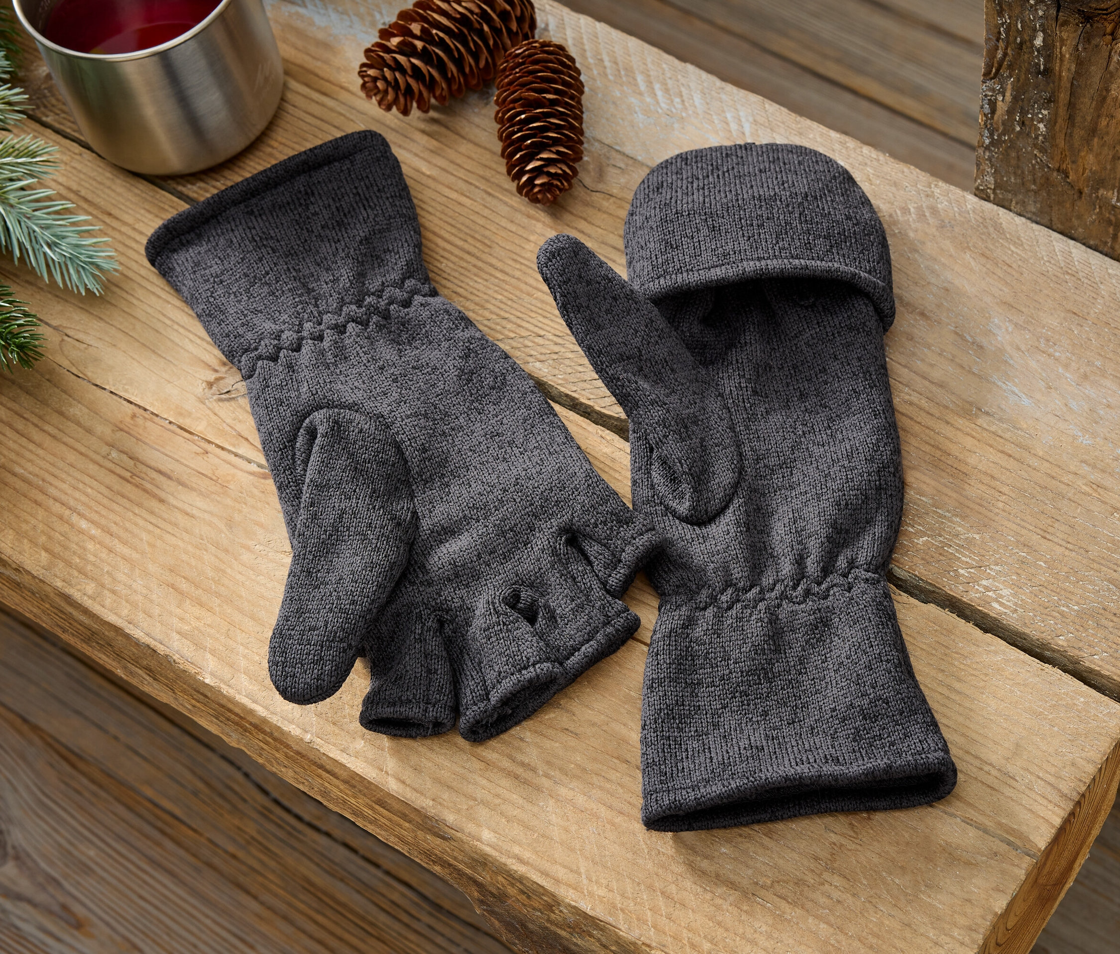 Dvoje šedé palčáky leží na dřevěné lavici vedle sebe.