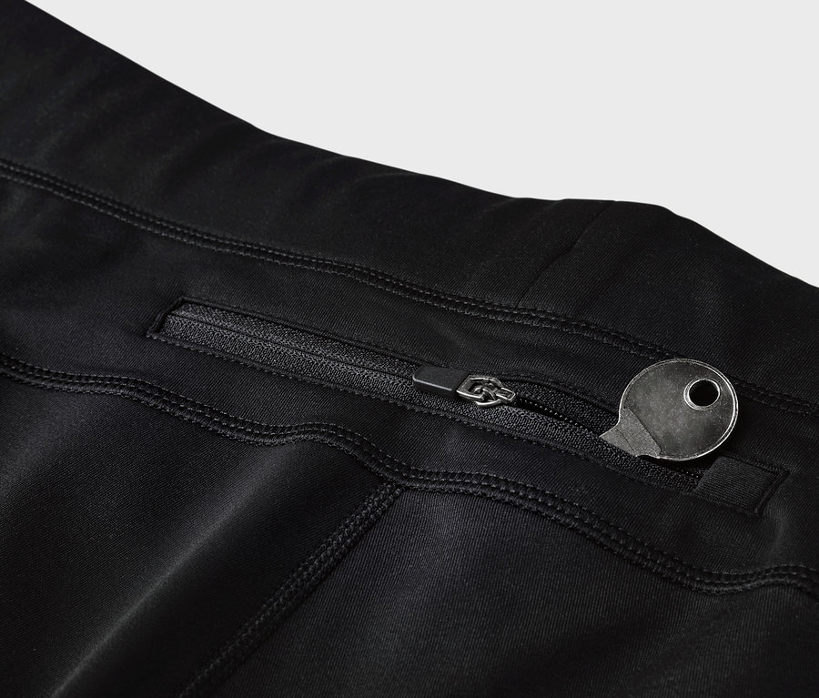 Detail černých legín s kapsou na zip a klíčem.
