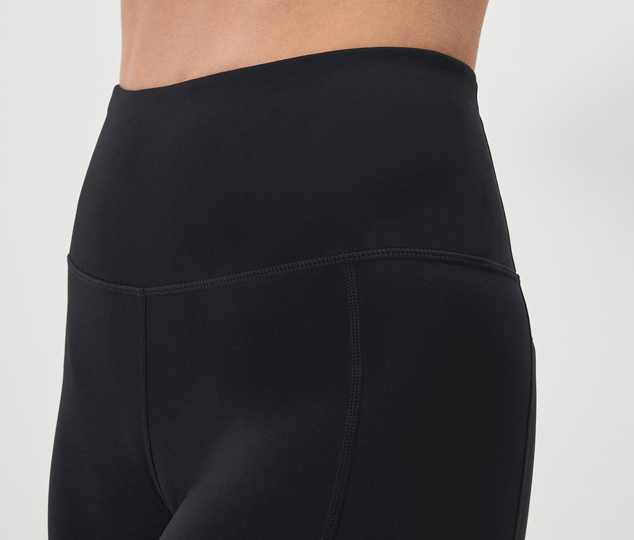 Detailní záběr na černé legíny na osobě.