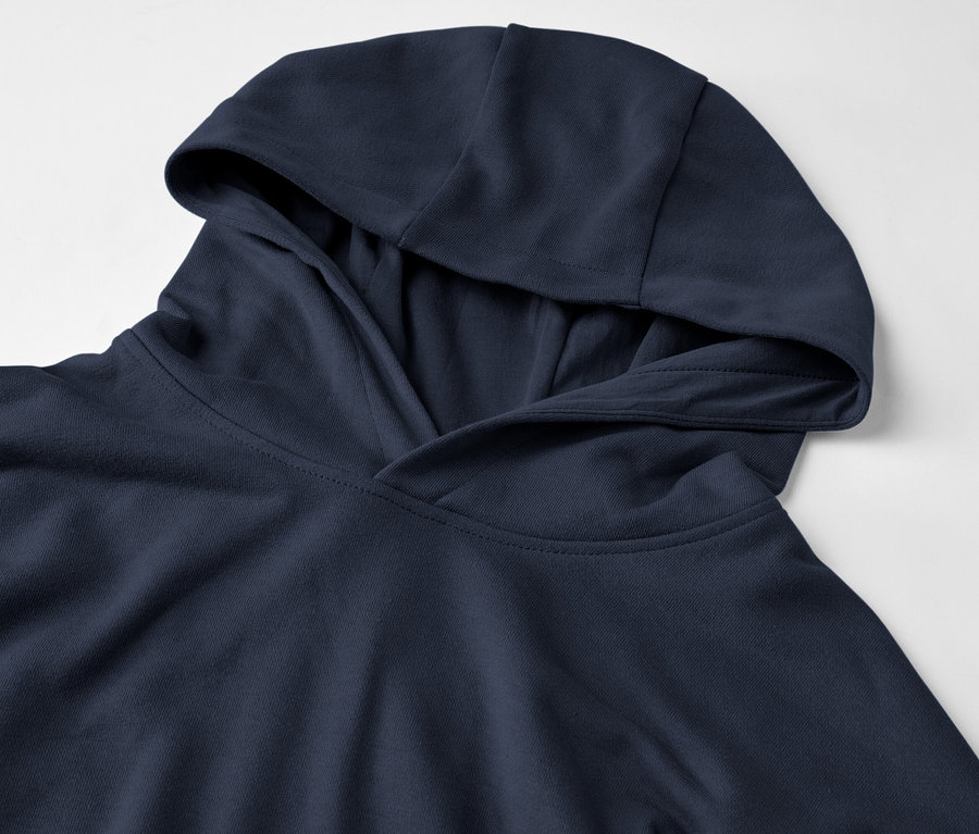 Detailní záběr tmavě modré mikiny s kapucí na bílém pozadí.