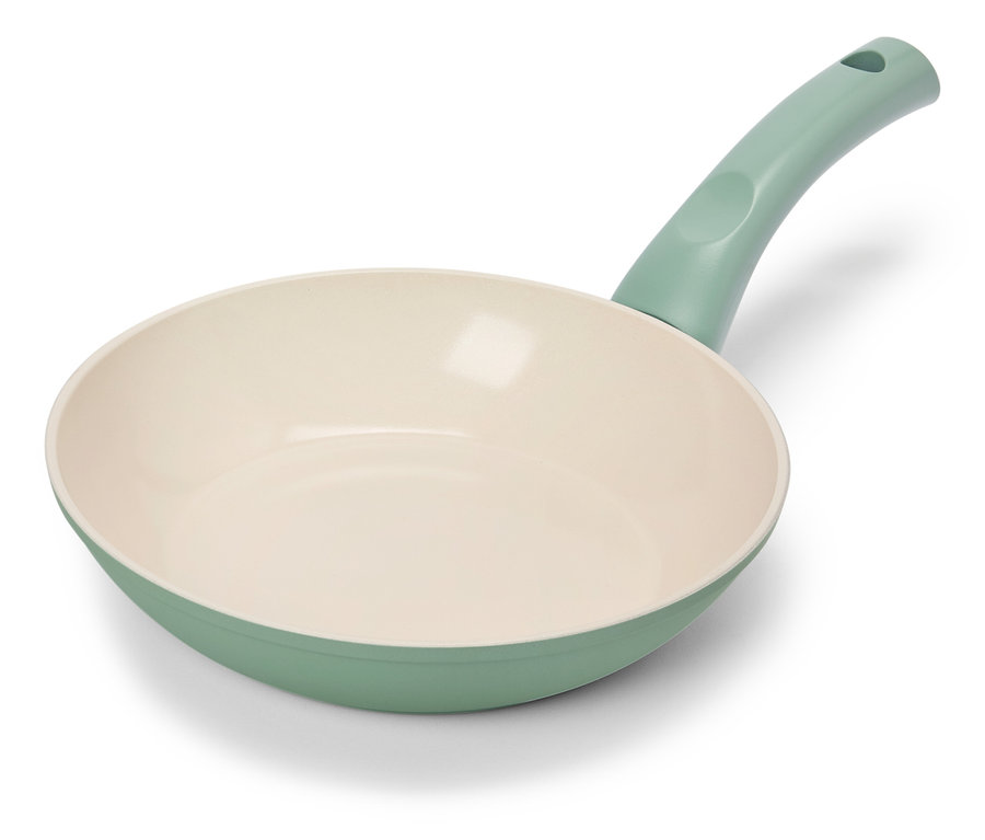 Světle zelená pánev s krémovým vnitřkem leží na bílém pozadí.