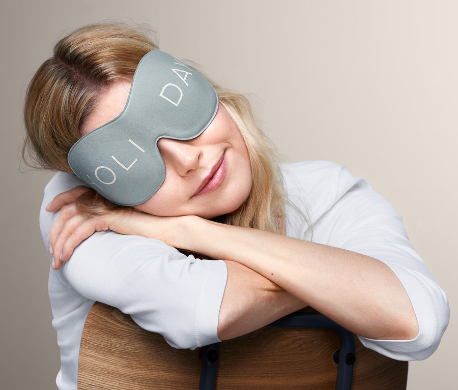 Žena s blond vlasy odpočívá s 3D maskou na spaní.