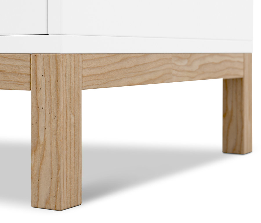 Detail bílého příborníku s dřevěnýma nohama.