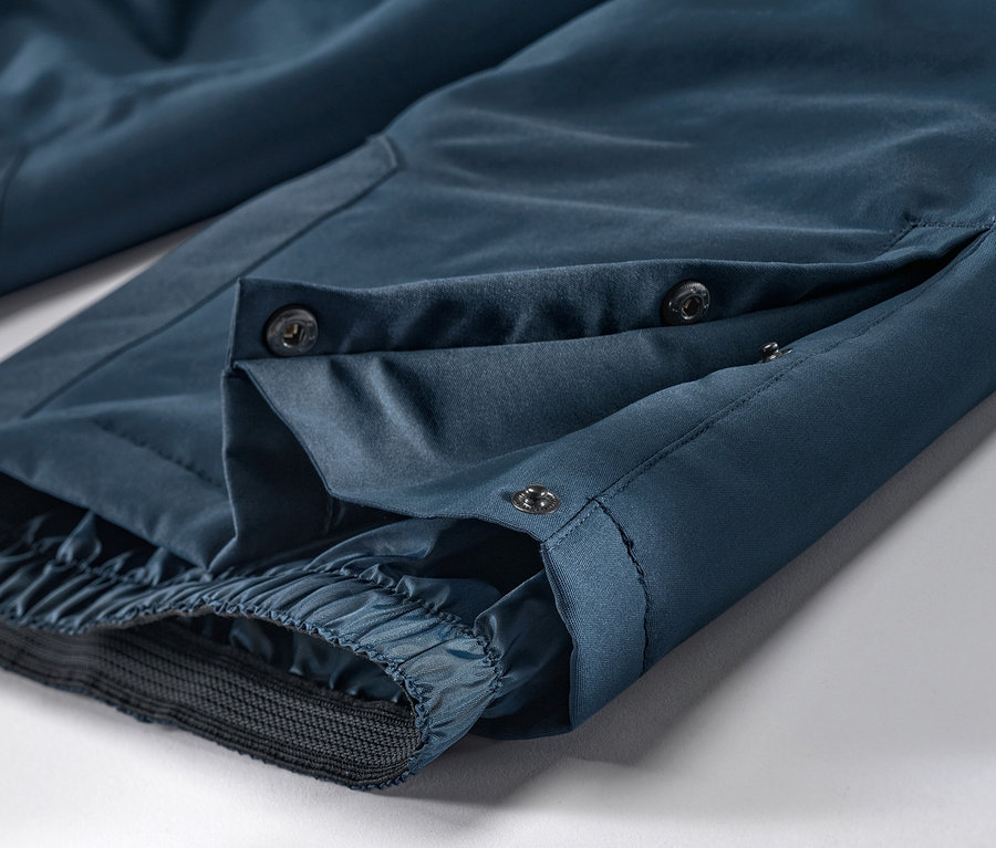 Detail námořnicky modrých lyžařských kalhot s knoflíky.