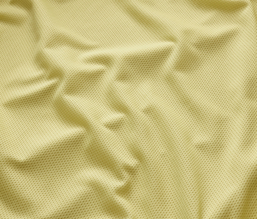 Detail žluté bundy do deště s texturou.