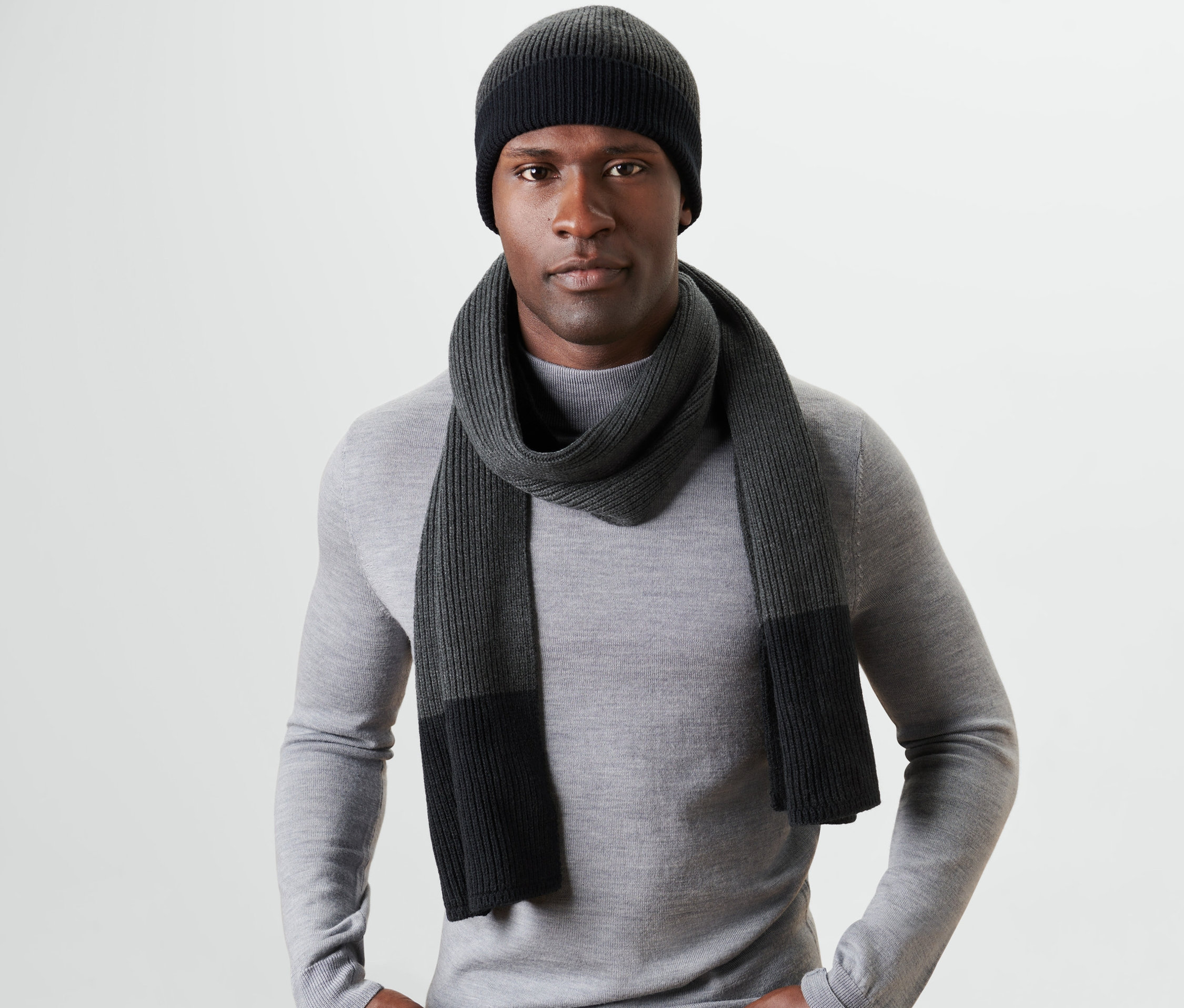 Muž nosí pletenou šálu a čepici.