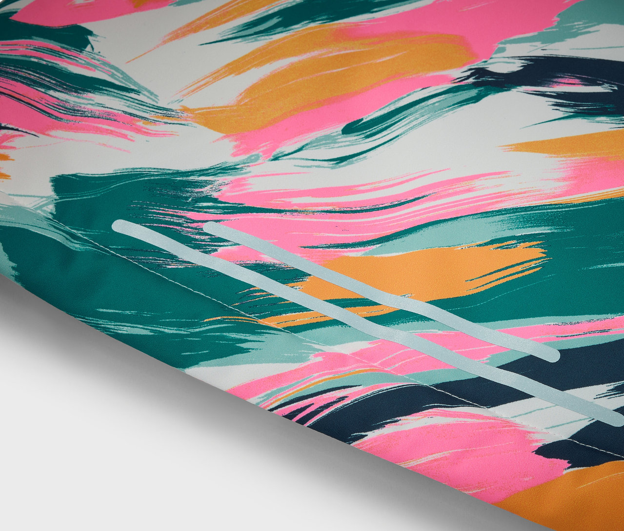 Detailní pohled na abstraktní vzor s tahy štětce v růžové, zlaté, modré a zelené barvě na bílém pozadí.