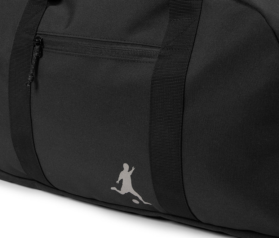 Detail černá sportovní taška s kapsou na zip a logem osoby hrající fotbal.