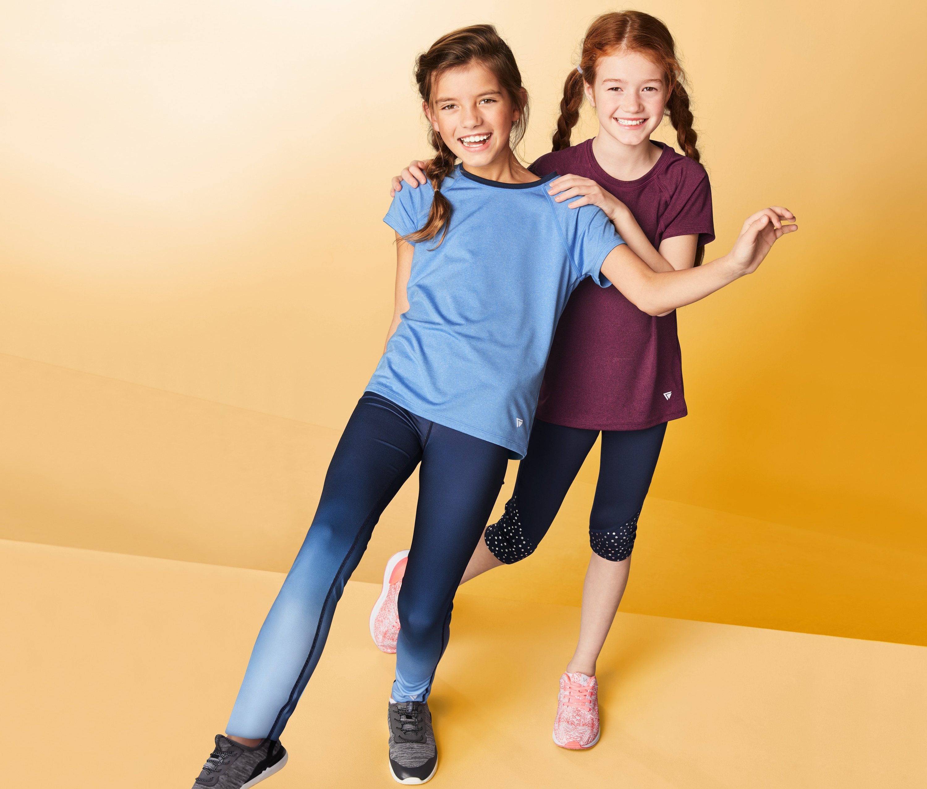 Dvě dívky pózují na žlutém pozadí a mají na sobě funkční trička, 2 ks.