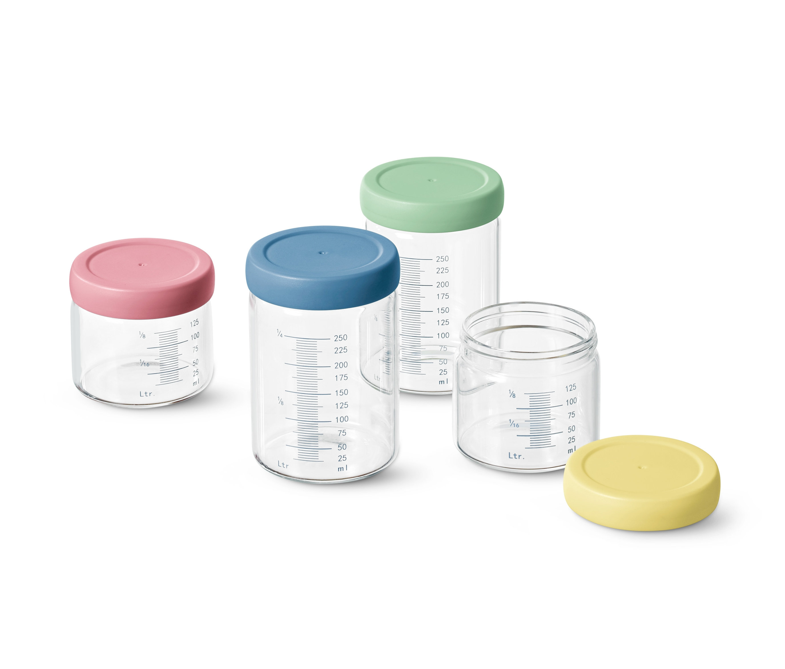 Čtyři dávkovací skleničky s barevnými víčky a stupnicí.