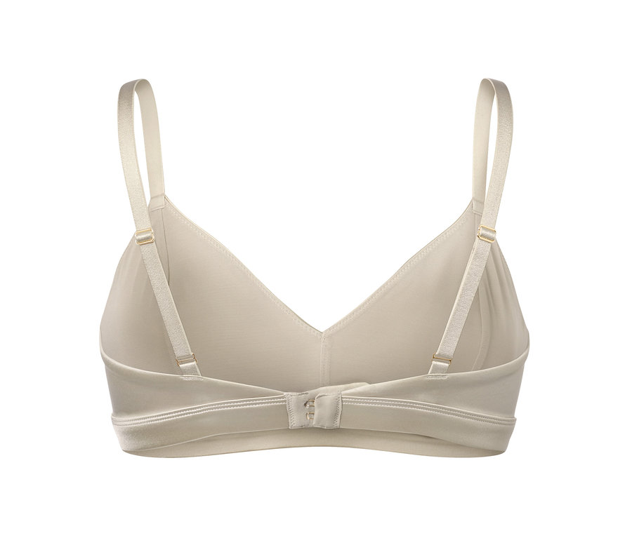 Detail krémové měkké podprsenky s nastavitelnými ramínky a zapínáním na háčky.