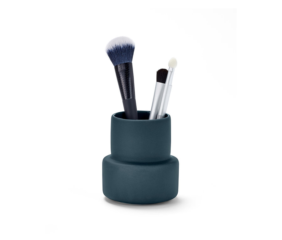V modrém košíku na drobnosti jsou tři štětce na make-up.