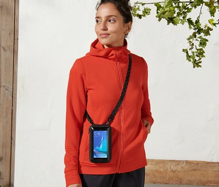 Žena má na sobě pouzdro na smartphone 2 v 1 s černým popruhem přes tělo.