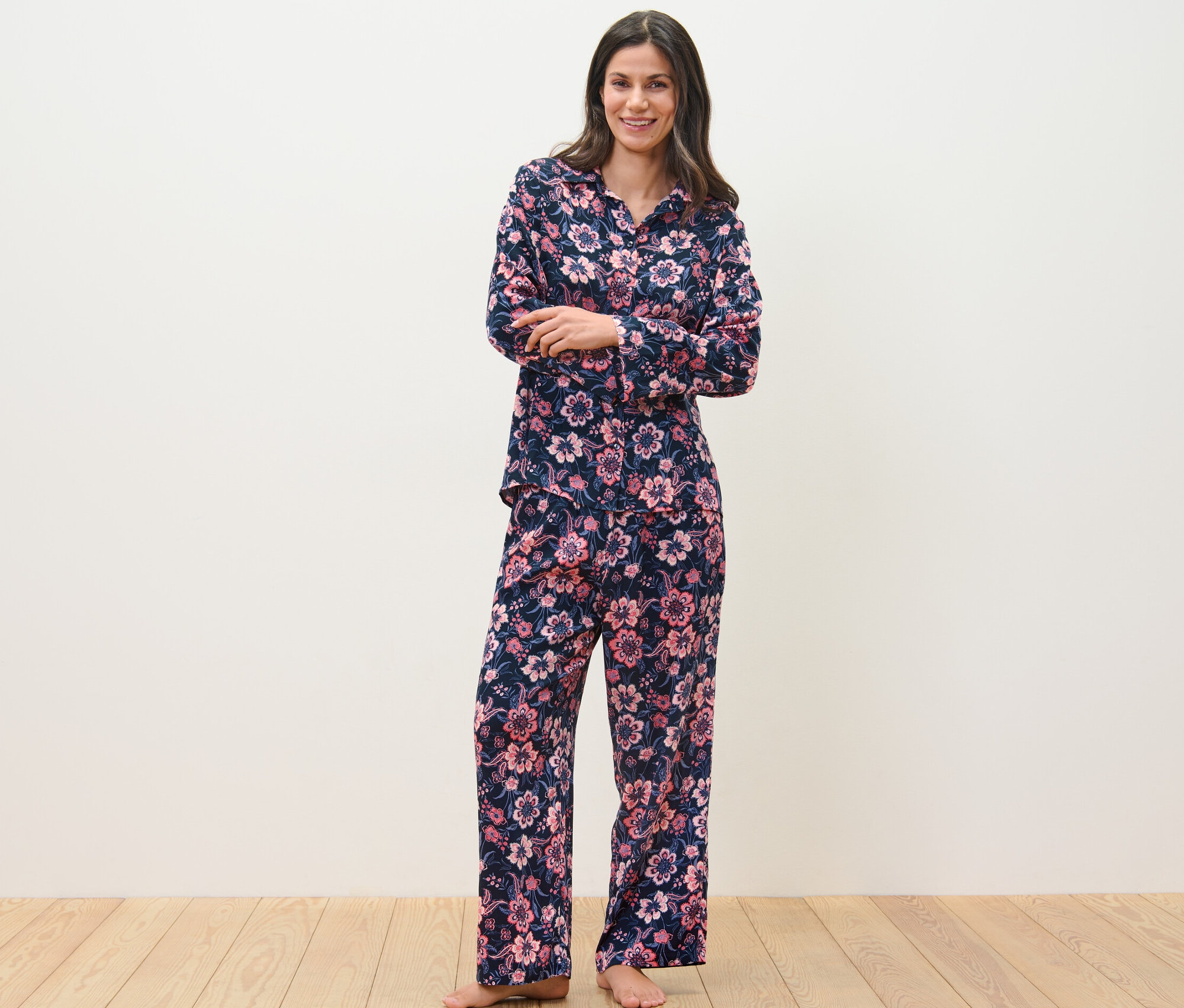 Žena stojí a má na sobě tkané pyžamo s květinovým vzorem.