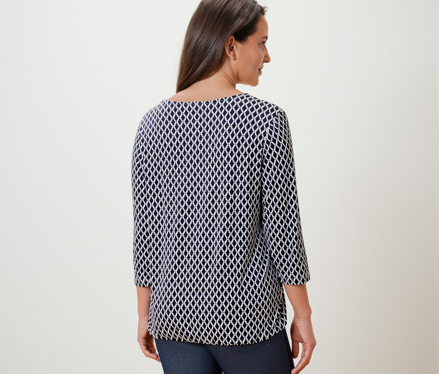 Žena má na sobě halenkové triko s potiskem.