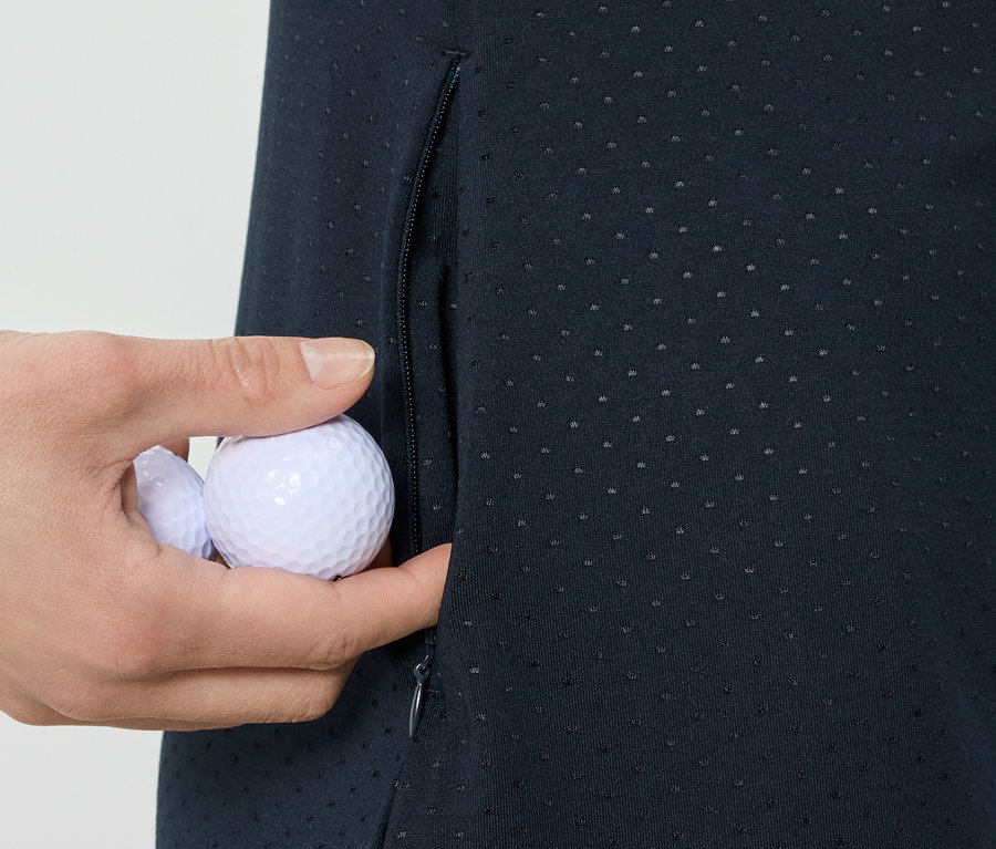 Ruka vkládá golfové míčky do kapsy sportovních šatů.