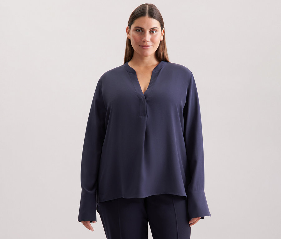 Žena má na sobě modrou tuniku Seidensticker z viskózy.