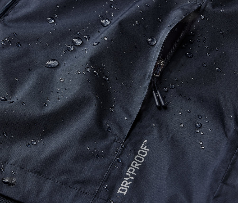 Detail námořnické modré bundy do deště s kapsou na zip a nápisem DRYPROOF.