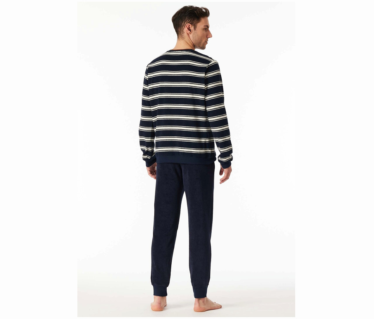 Muž zády k fotoaparátu má na sobě pruhovaný top a tmavě modré kalhoty.