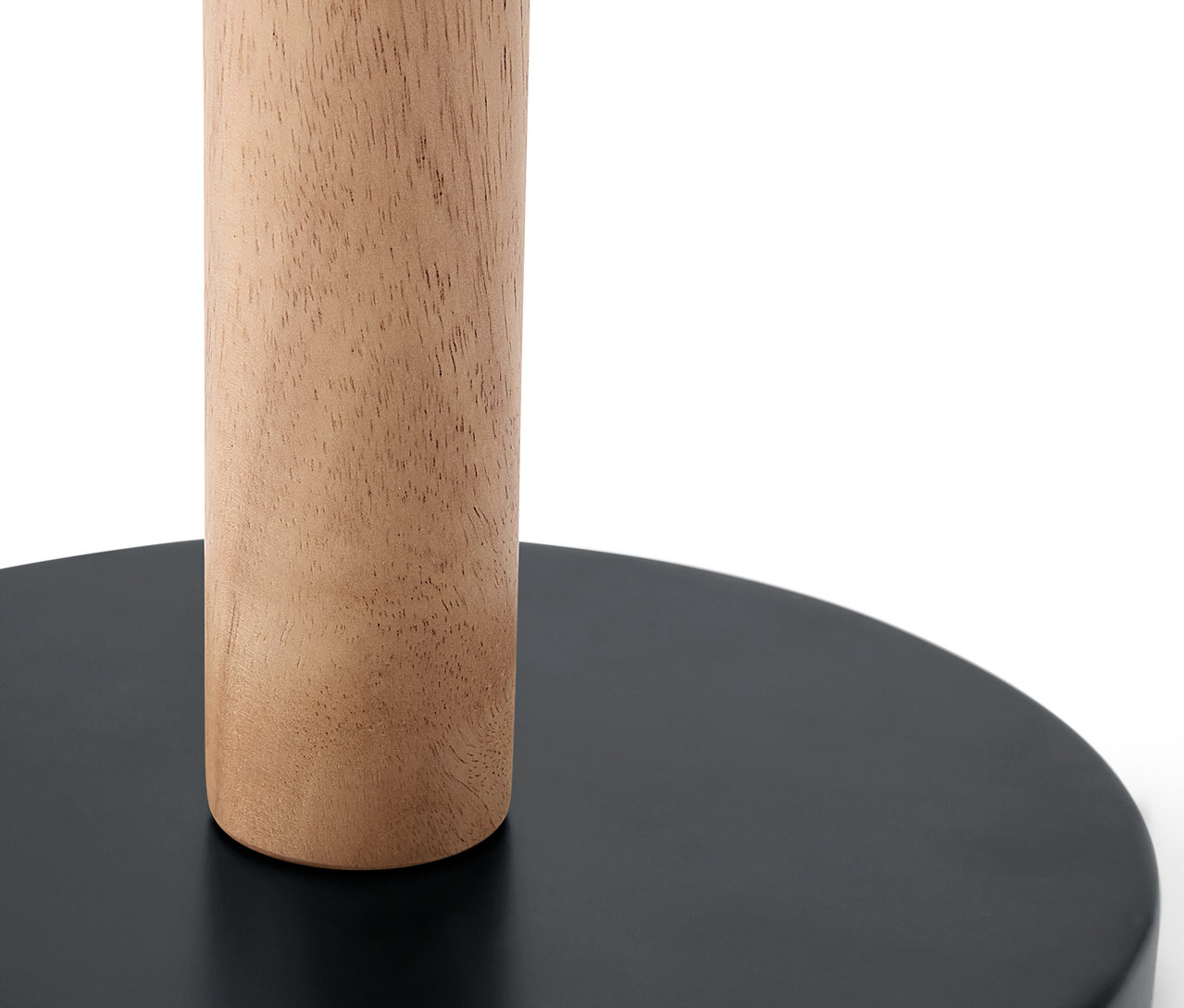 Detail dřevěného sloupku na černé kulaté základně.