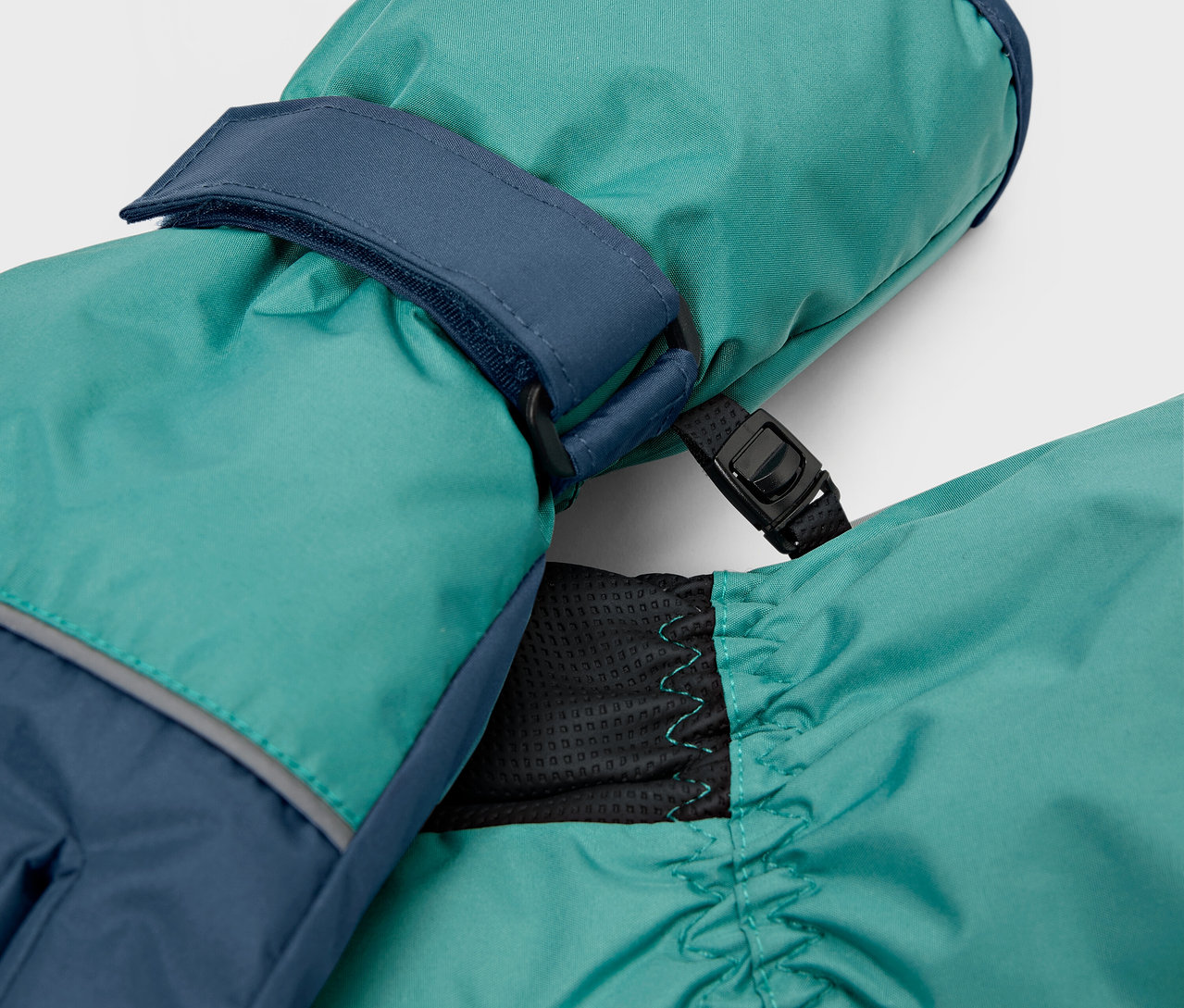 Detailní záběr na tyrkysové palčáky s tmavě modrými detaily.