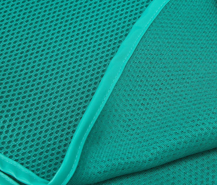 Detailní záběr dvou vrstev tyrkysové síťoviny, jedné hrubé a jedné jemné.