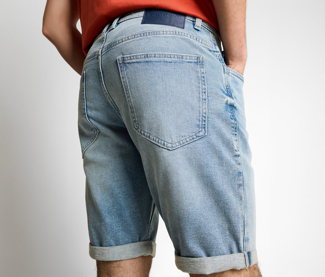 Muž zezadu v džínových šortkách Tom Tailor TTJOSH REGULAR SLIM, light stone blue denim, s rukama v kapsách.