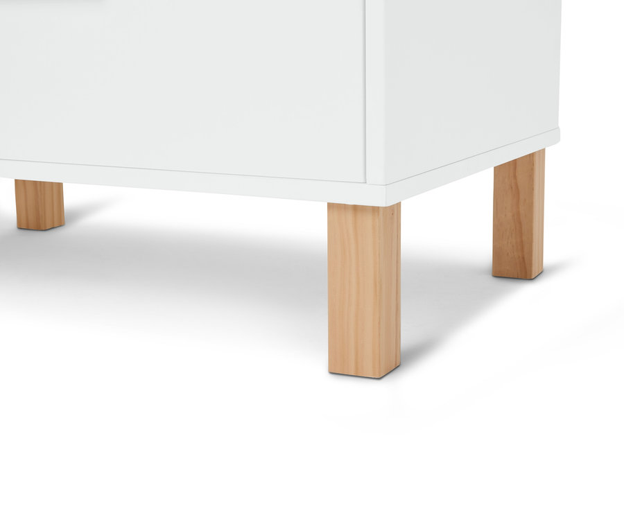 Detailní záběr na bílou skříňku se světle hnědýma dřevěnýma nohama.