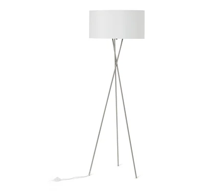 Stojací lampa s bílým válcovým stínidlem a stříbrnou trojnohou základnou. Bílý napájecí kabel vede od základny.