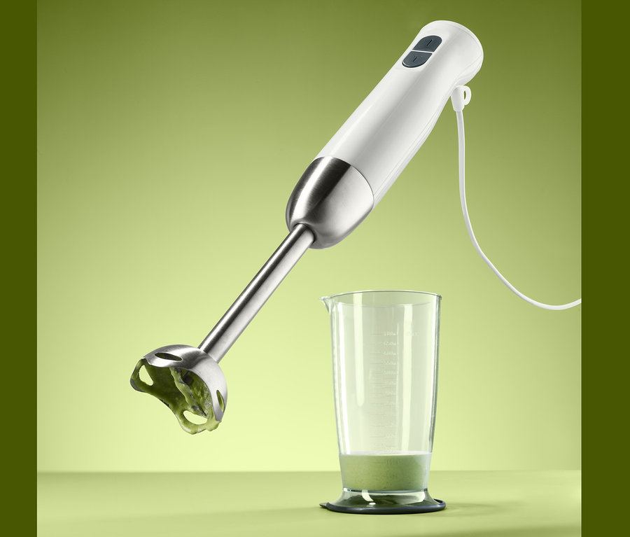 Tyčový mixér nad sklenicí s obsahem.