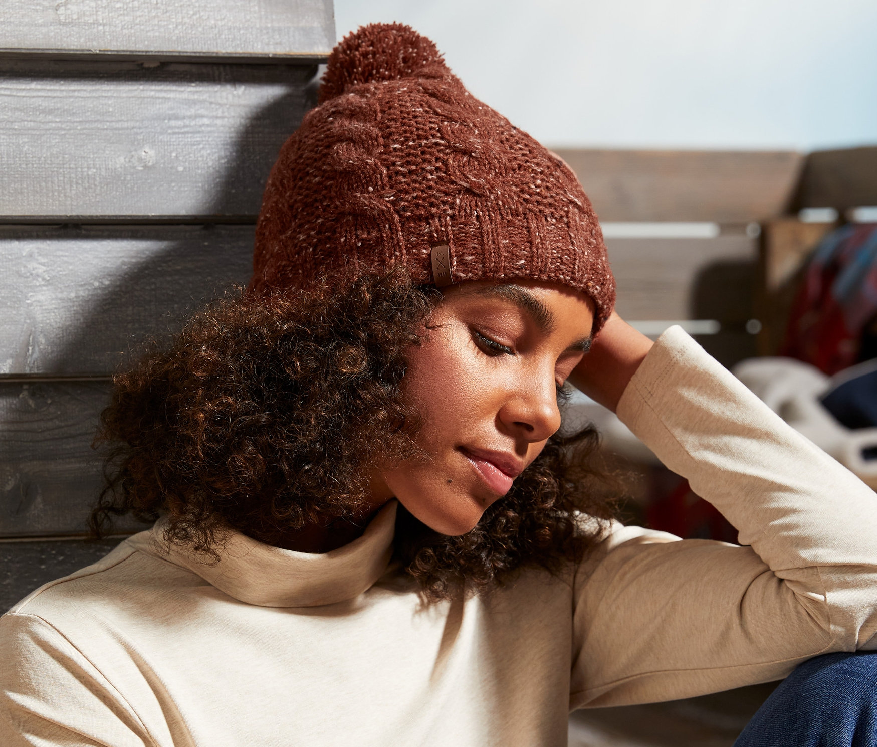 Žena sedí a má na sobě pletenou čepici.