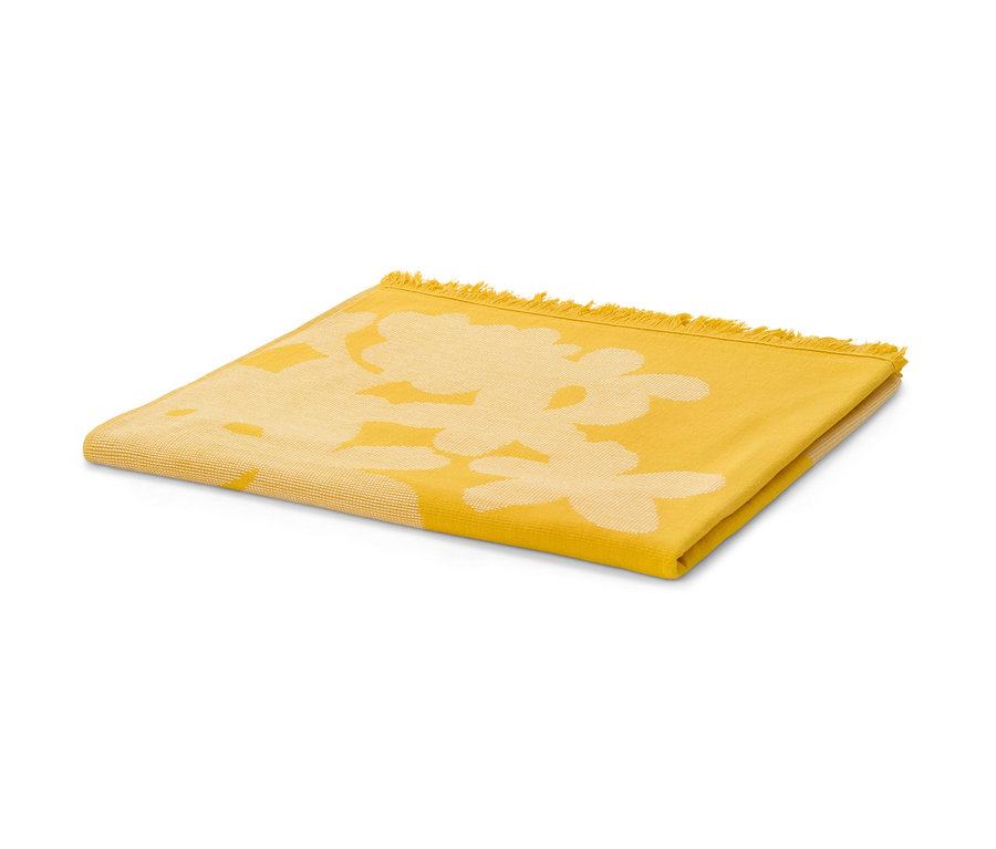Žlutá XL osuška hammam s květinovým vzorem leží složená na bílém pozadí.