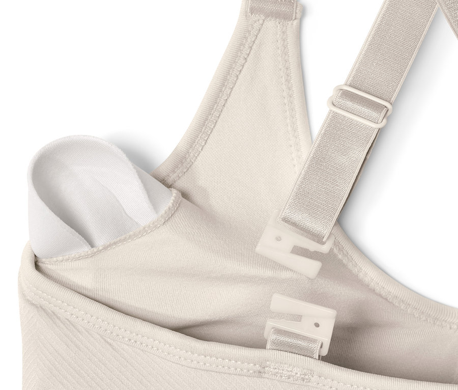 Detail krémově bílé bezešvé sportovní podprsenky.