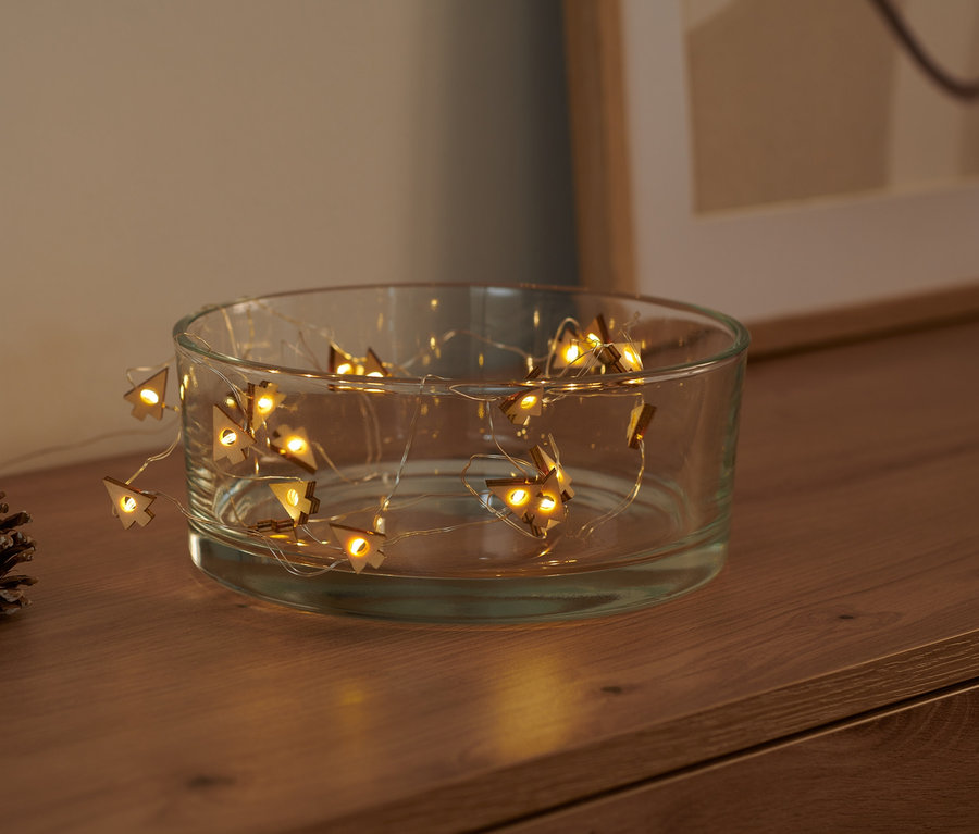 LED světelný mikrořetěz Stromečky v průhledné skleněné misce, vedle leží borová šiška.