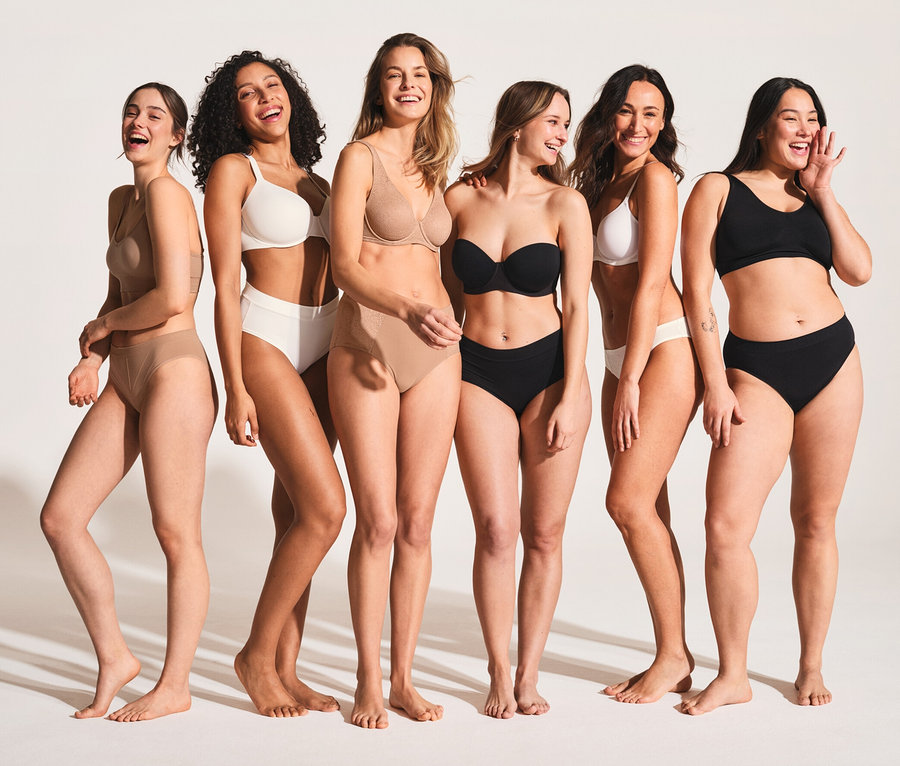 Šest usmívajících se žen v spodním prádle stojí vedle sebe. Ženy mají na sobě černé a bílé podprsenky SCHIESSER s biobavlnou.