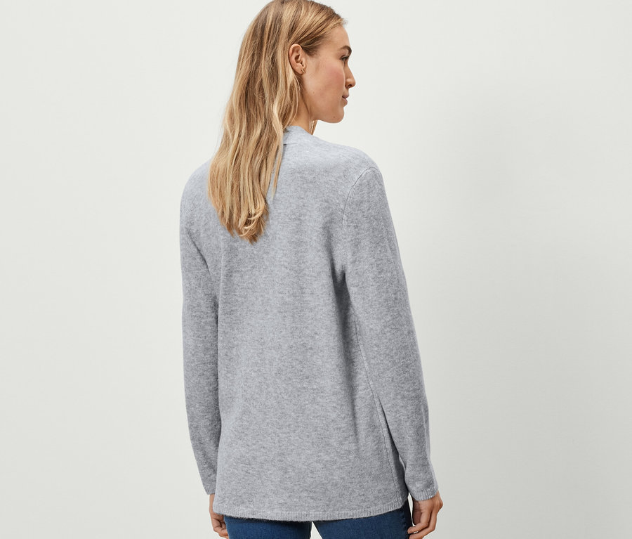 Žena má na sobě otevřený kardigan.