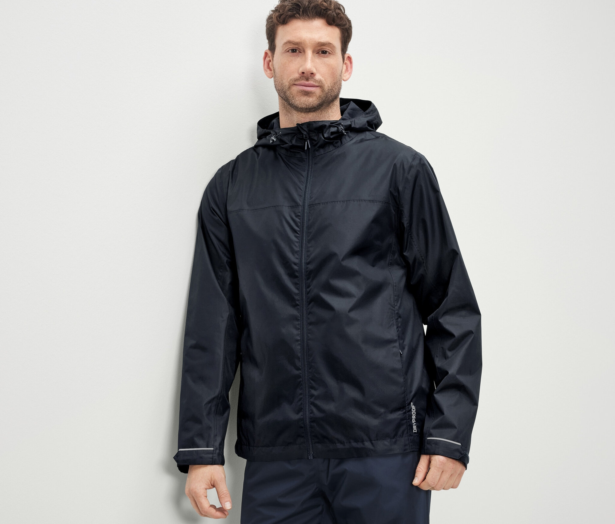 Muž má na sobě unisexovou bundu do deště.