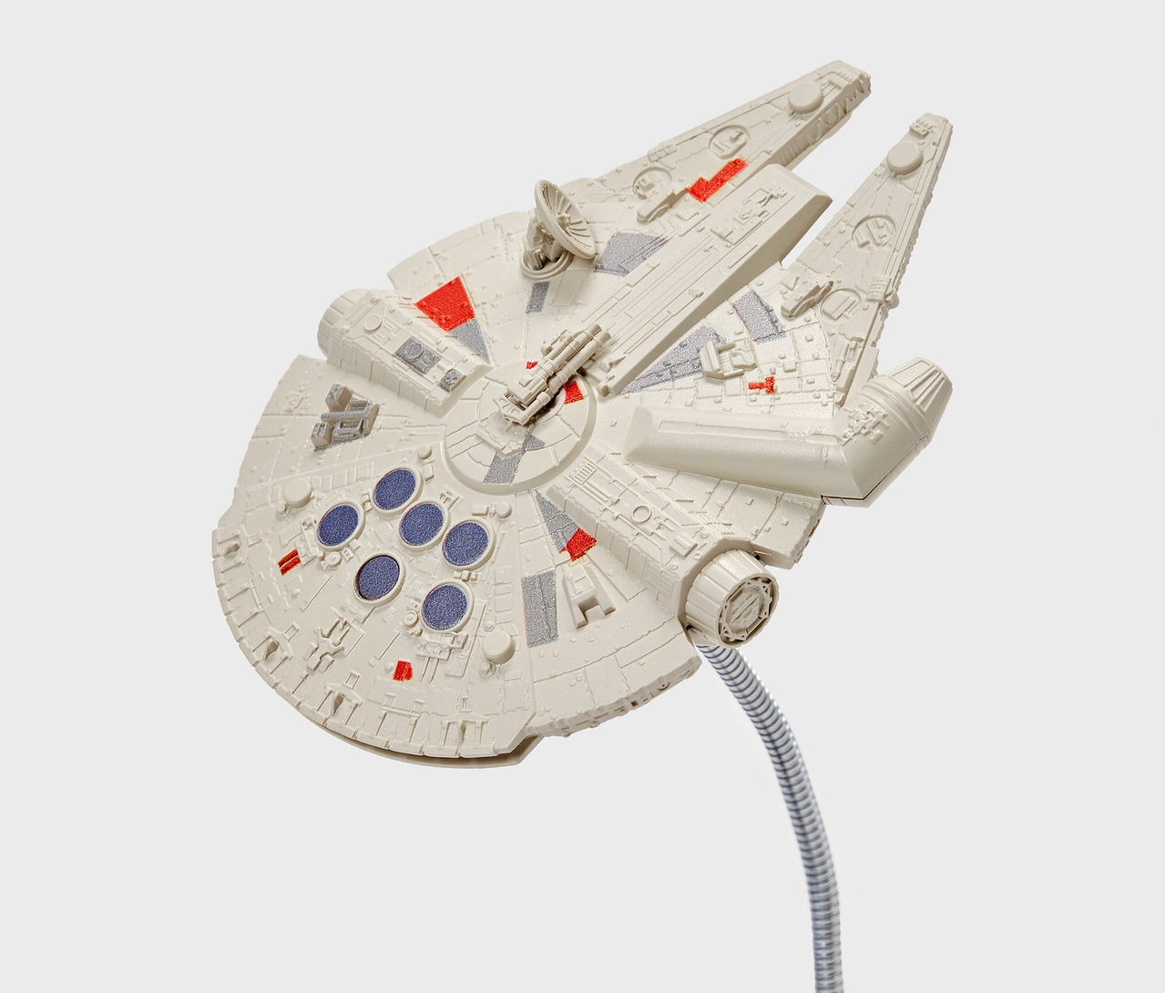 Model lodi Millennium Falcon s detaily červené a šedé barvy, upevněná na ohebném stříbrném stonku.
