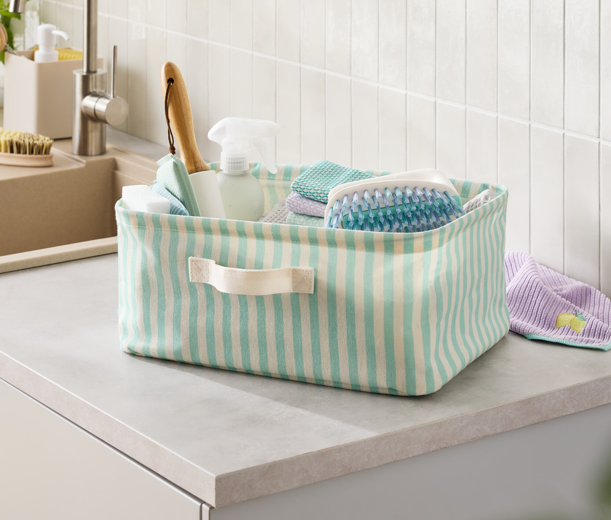 Pruhovaný koš s čisticími prostředky na lince.