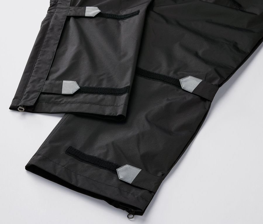 Detailní pohled na high-tech kalhoty do deště černé barvy.